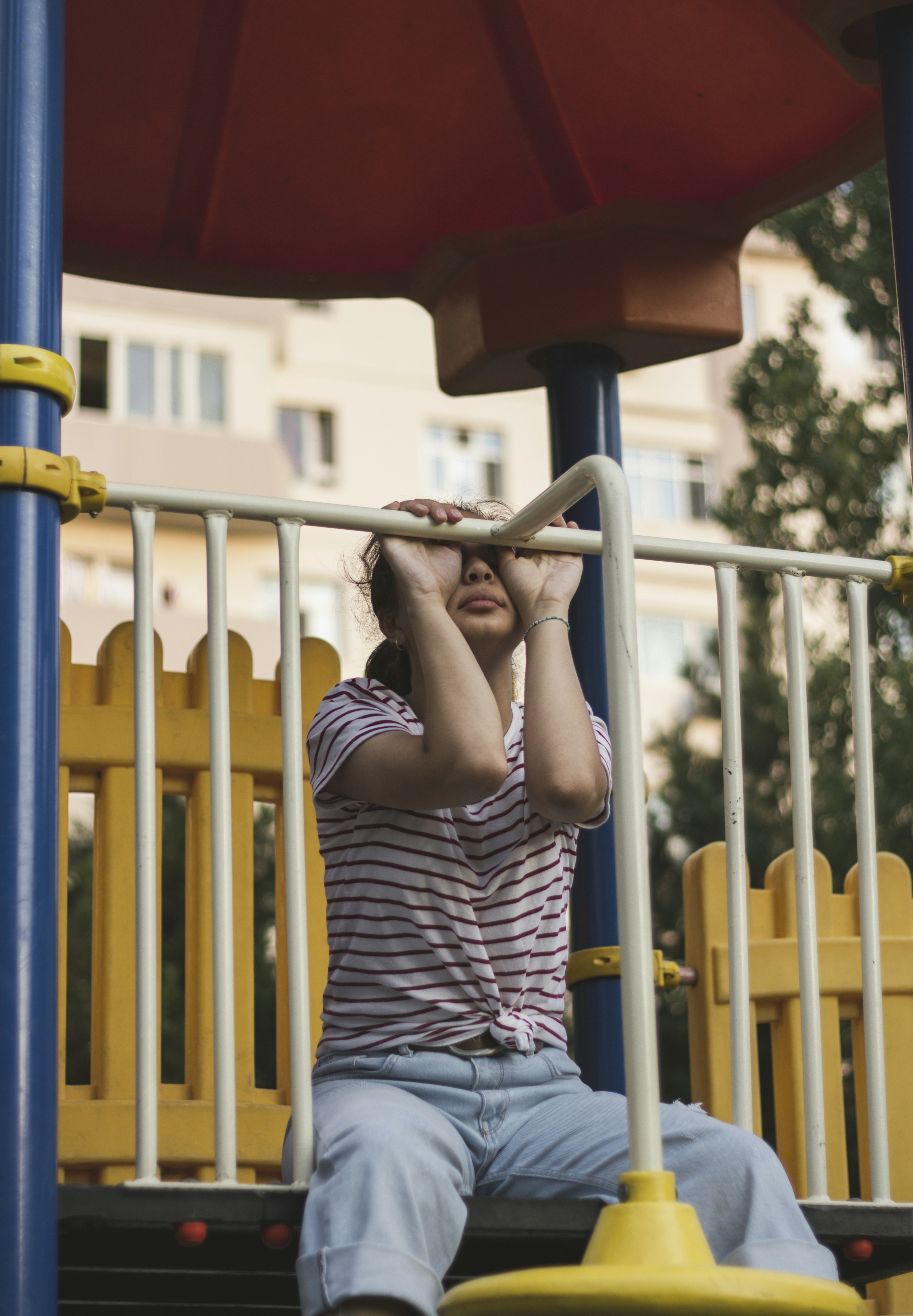 Ein junges Mädchen, das auf einer Rutsche auf einem Spielplatz sitzt