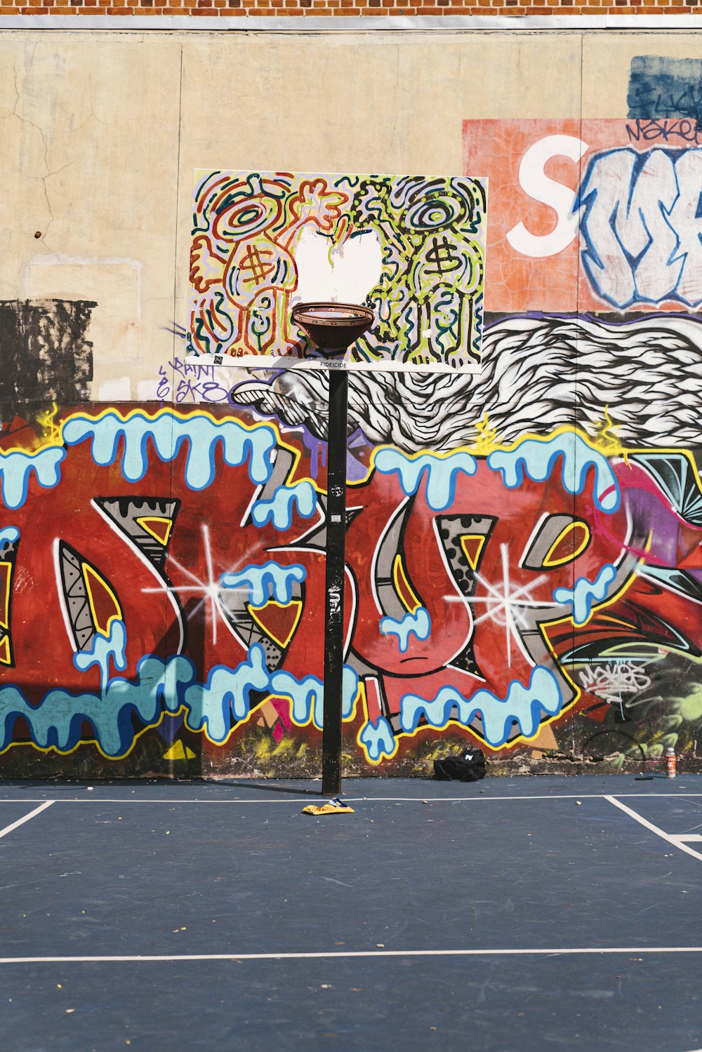 painted basketball hoop near graffiti wall