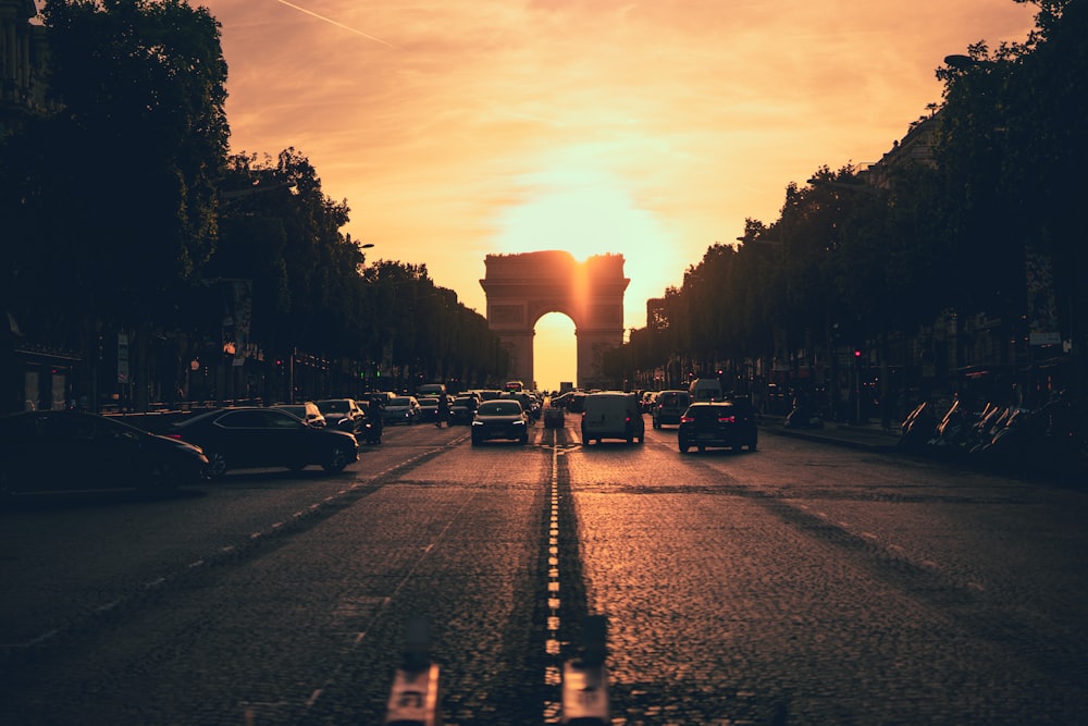 the sun is setting over a city street