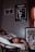 A person is relaxing in a papasan chair, holding a remote. The room features dark walls with several posters, including ones for The Weeknd's 'Trilogy' and the film 'Casablanca'. The lighting suggests a cozy, subdued atmosphere.