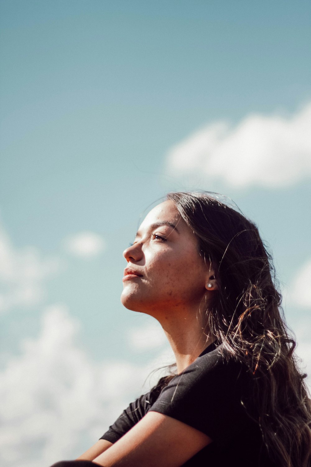 woman in black shirt under blue and white cloudy sky