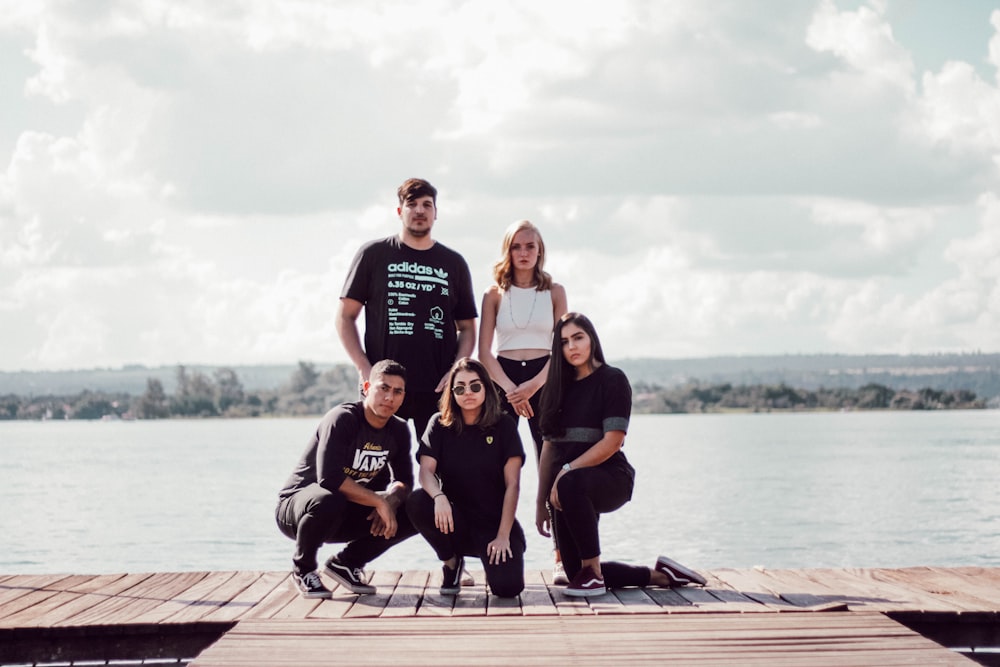 a group of people posing for a picture on a dock