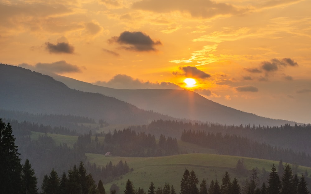 the sun is setting over a mountain range