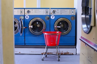 a red basket sitting in front of a row of washers