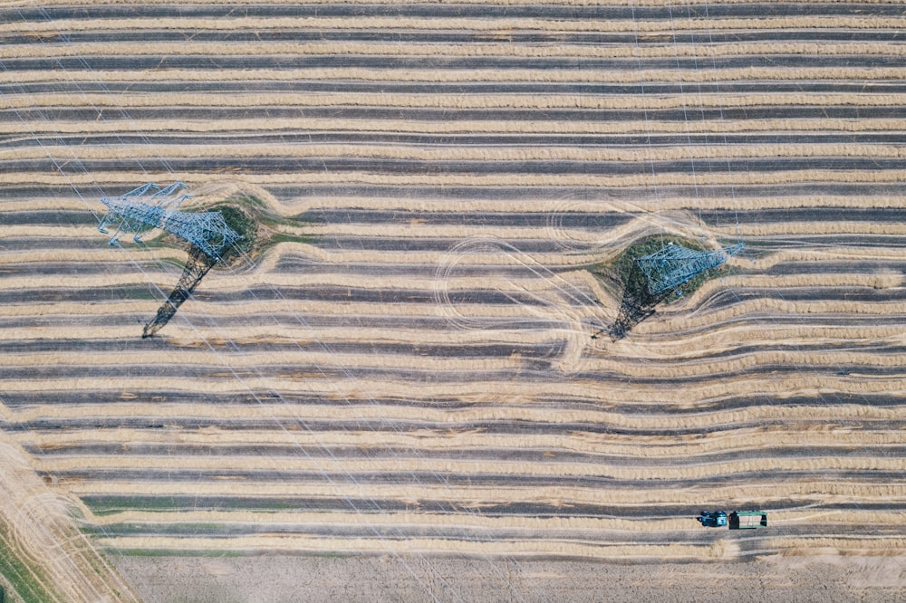 an aerial view of two blue umbrellas in the middle of a field