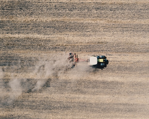 An aerial view of a John Deere tractor working on a farm.