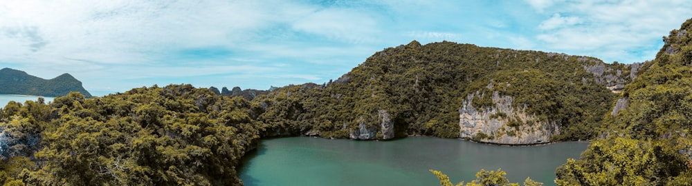 body of water beside mountain at daytime