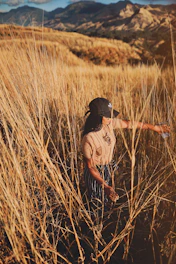 woman standing on brown grass field during daytime