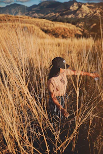 woman standing on brown grass field during daytime