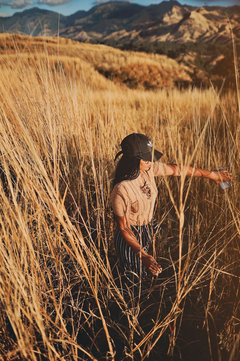 昼間、茶色の草原に立つ女性