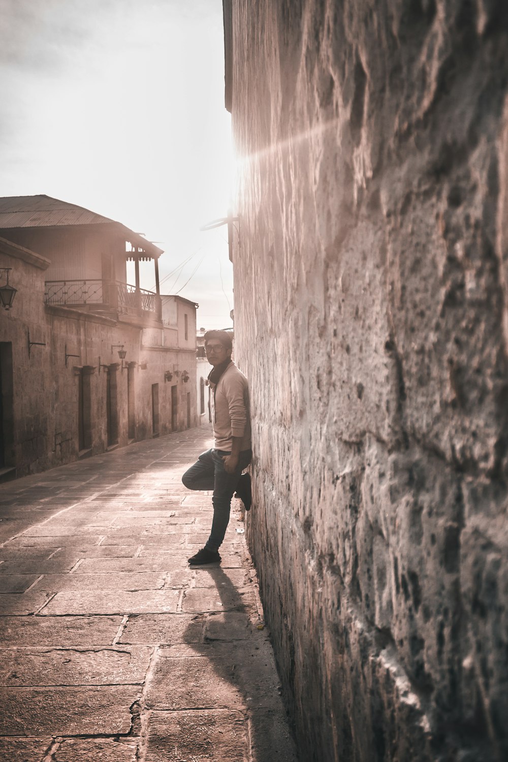 man leaning on concrete wall