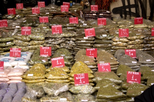 Close-up of various packaged spices and dried herbs on a market stall.