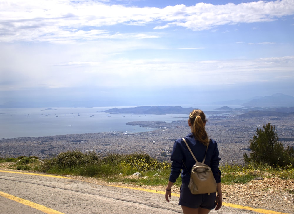 woman in navy-blue long-sleeved shirt wearing gray leather backpack