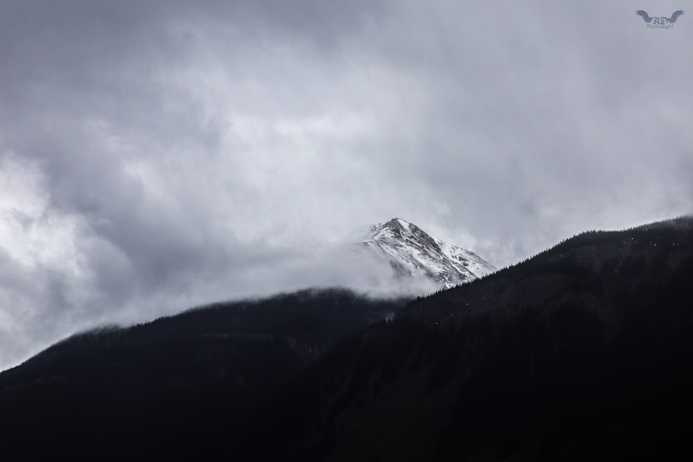 a snow covered mountain under a cloudy sky