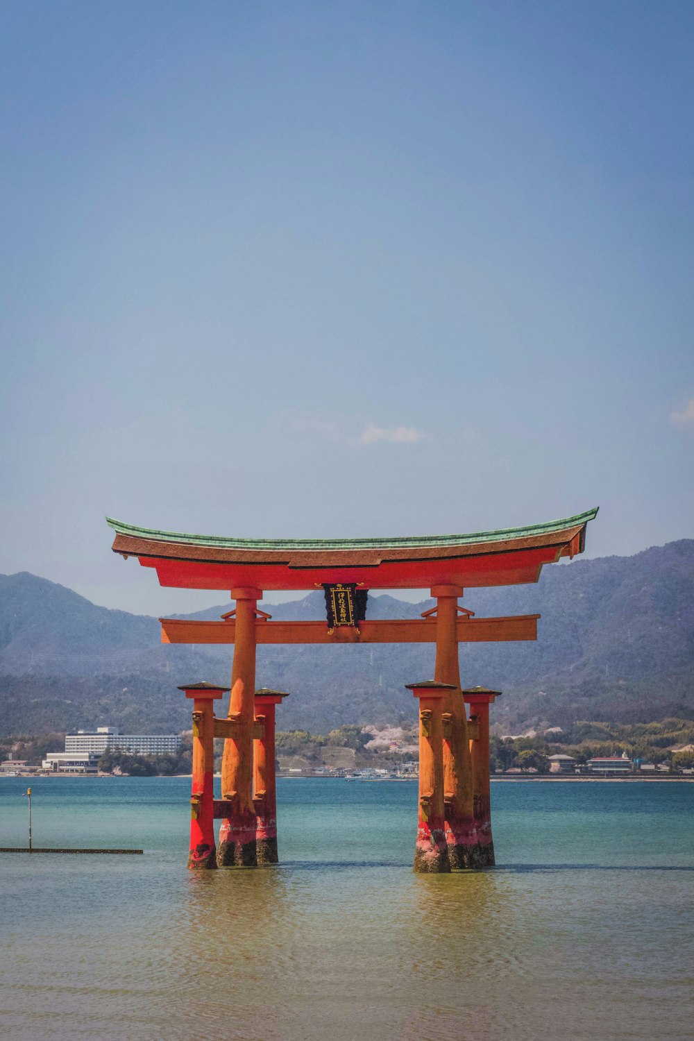 red wooden temple on body of water