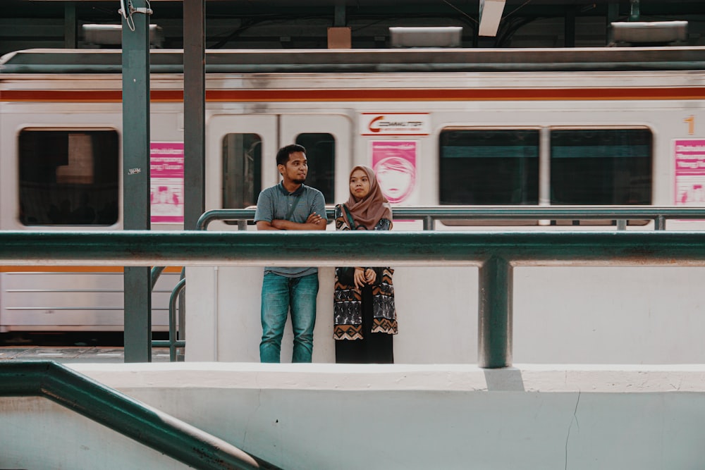 man and woman standing near train