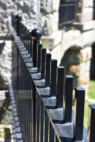 Close-up of a sturdy steel fence panel with a sleek black finish under bright Australian sunlight.
