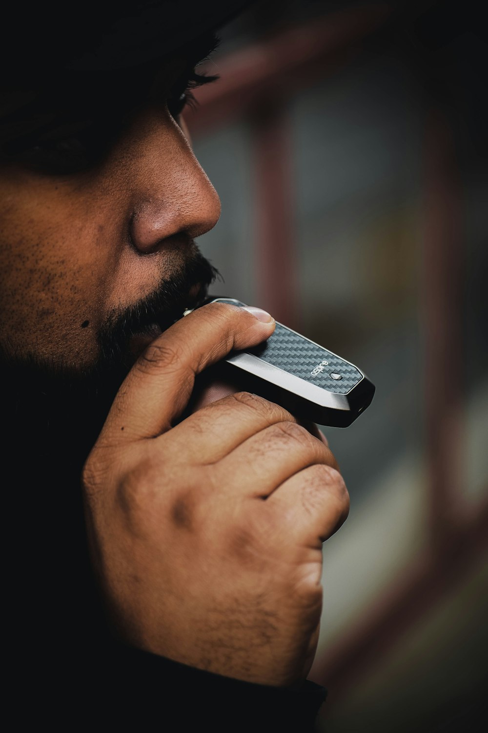 man biting black electronic device