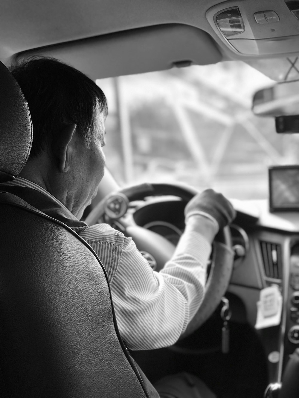grayscale photography of man driving vehicle