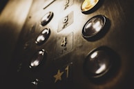 Close-up of a hydraulic elevator control panel with polished buttons and safety indicators.