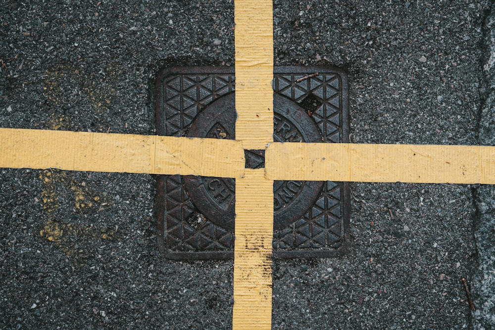 a yellow line is across the street from a manhole cover