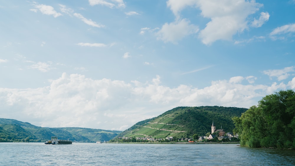 calm body of water near mountains during daytime