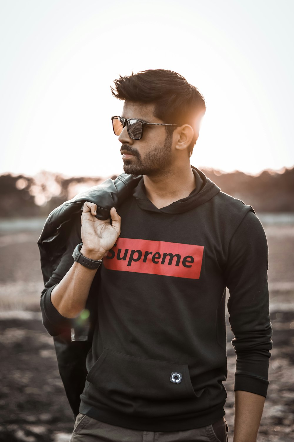 photo peu profonde de l’homme en noir Supreme pullover sweat à capuche