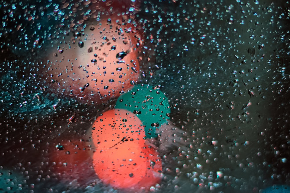 Fotografía bokeh de gotas de agua en una superficie de vidrio transparente