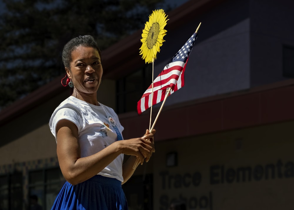 mujer con camiseta blanca sosteniendo la bandera de EE. UU.