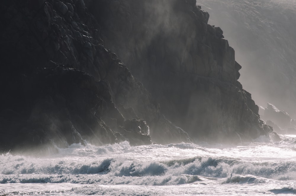 a person riding a surfboard on a wave covered beach