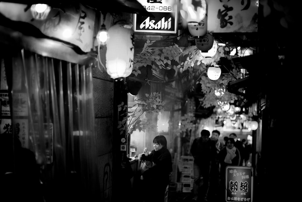 a black and white photo of people walking down a street