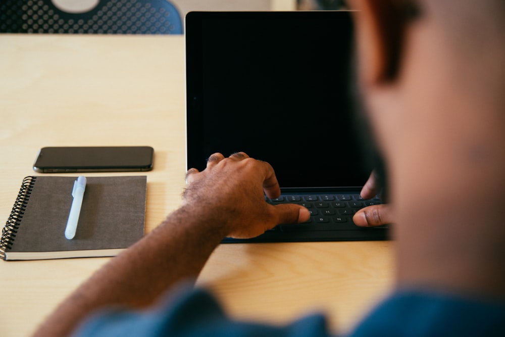 man typing on laptop