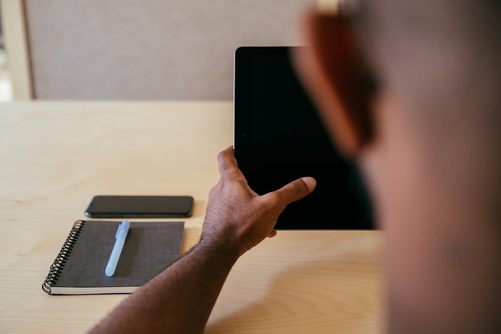 person holding black tablet computer