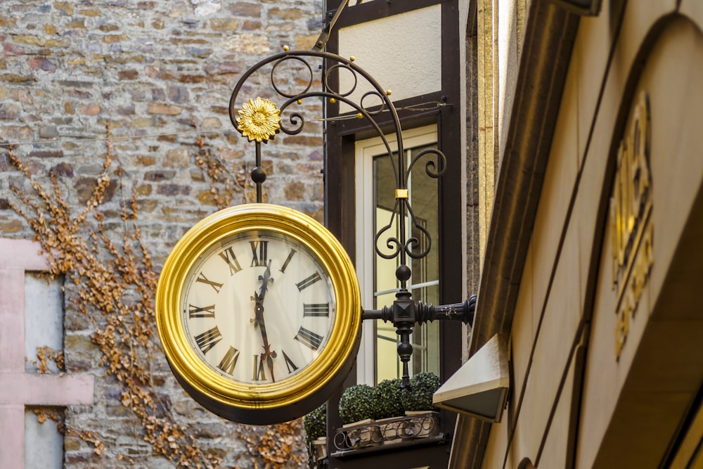 eine Uhr, die an der Seite eines Gebäudes hängt