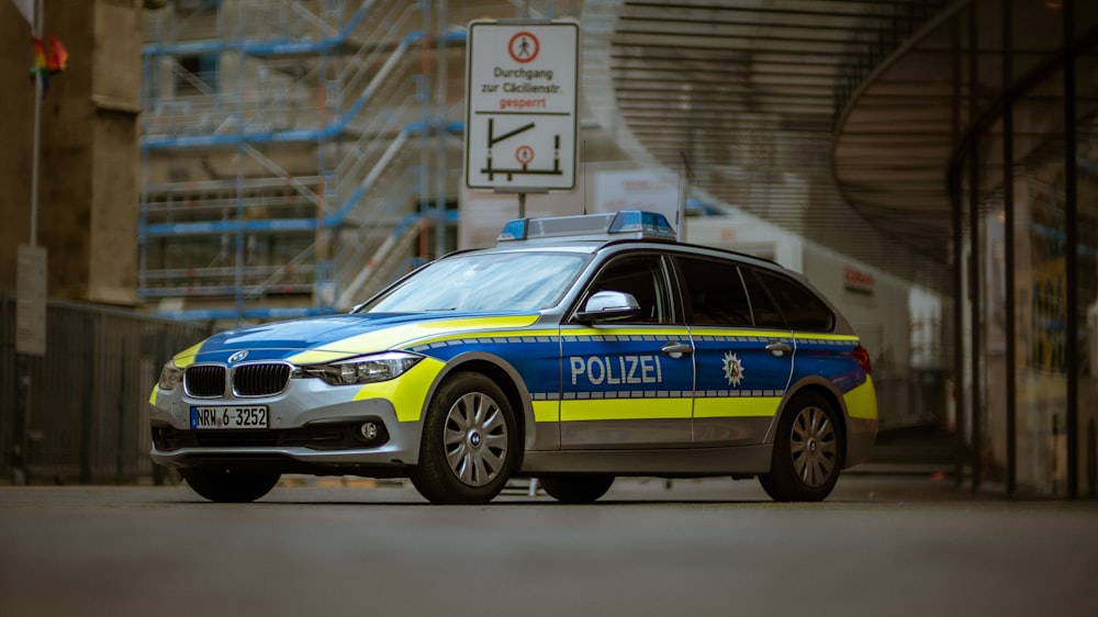 blue and yellow police car on road