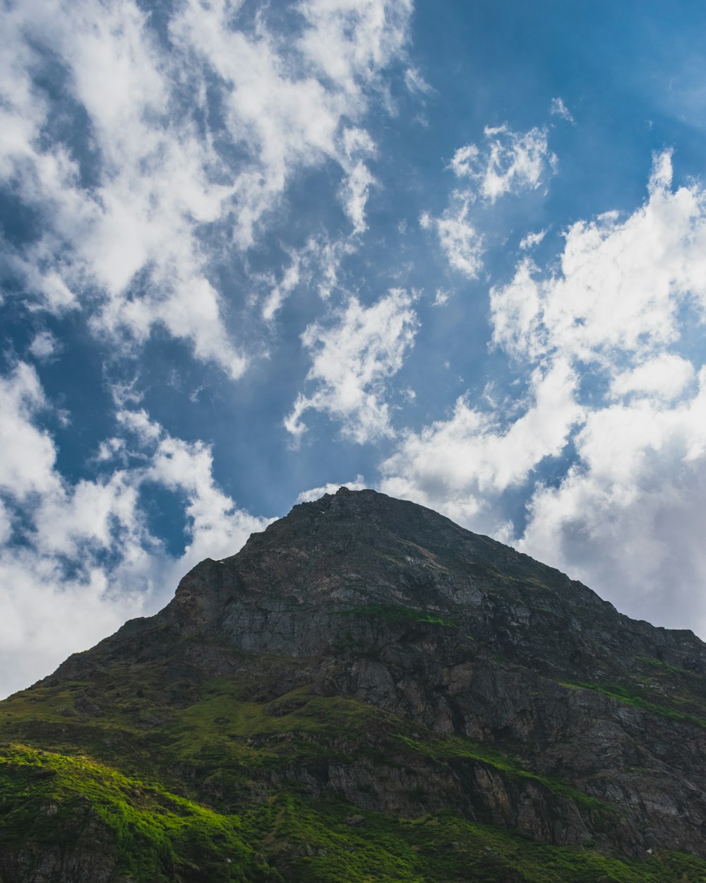 mountain and field view under blue and white skies