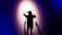 A person wearing a virtual reality headset is standing with their back to the camera, facing a wall with arms outstretched. Shadows are cast on the wall, creating a dramatic effect under a spotlight. The scene is enveloped in dark blue and purple tones, enhancing the sense of immersion and technology.