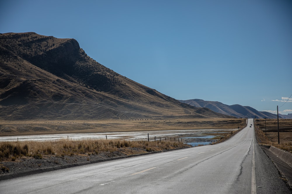 gray concrete road with no vehicle viewing mountain