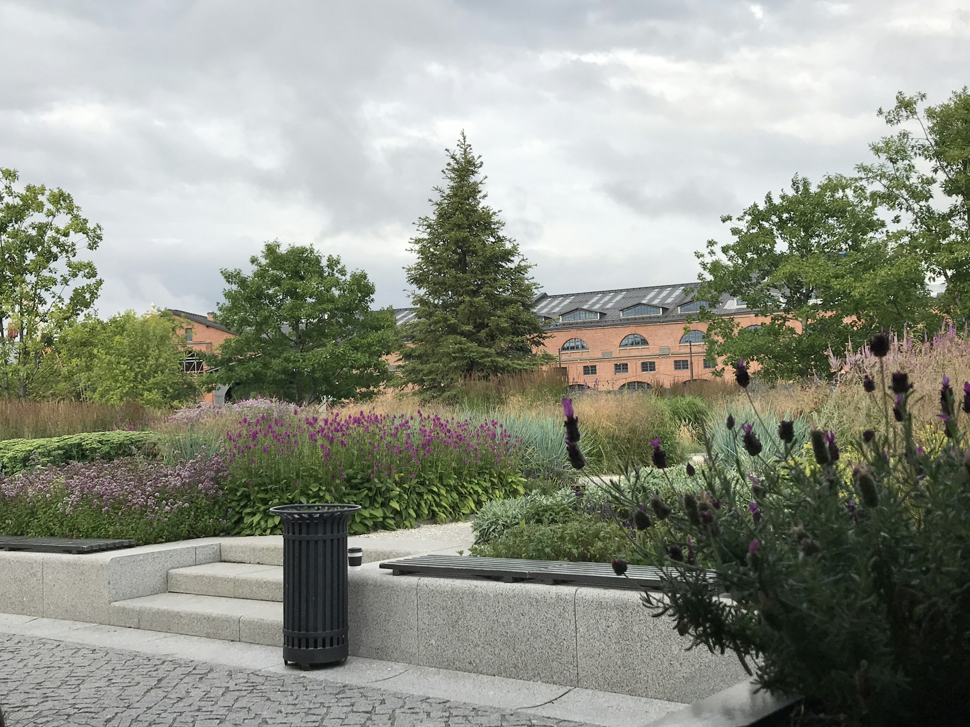 A serene garden area within a residential project featuring walking paths, seating spaces, and vibrant landscaping under a clear blue sky.