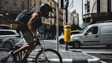 A city street view with a courier riding swiftly between cars.