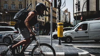 Courier riding a bicycle through a busy urban street.