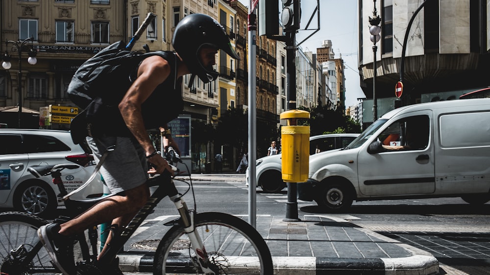 uomo in mountain bike con casco nero in strada
