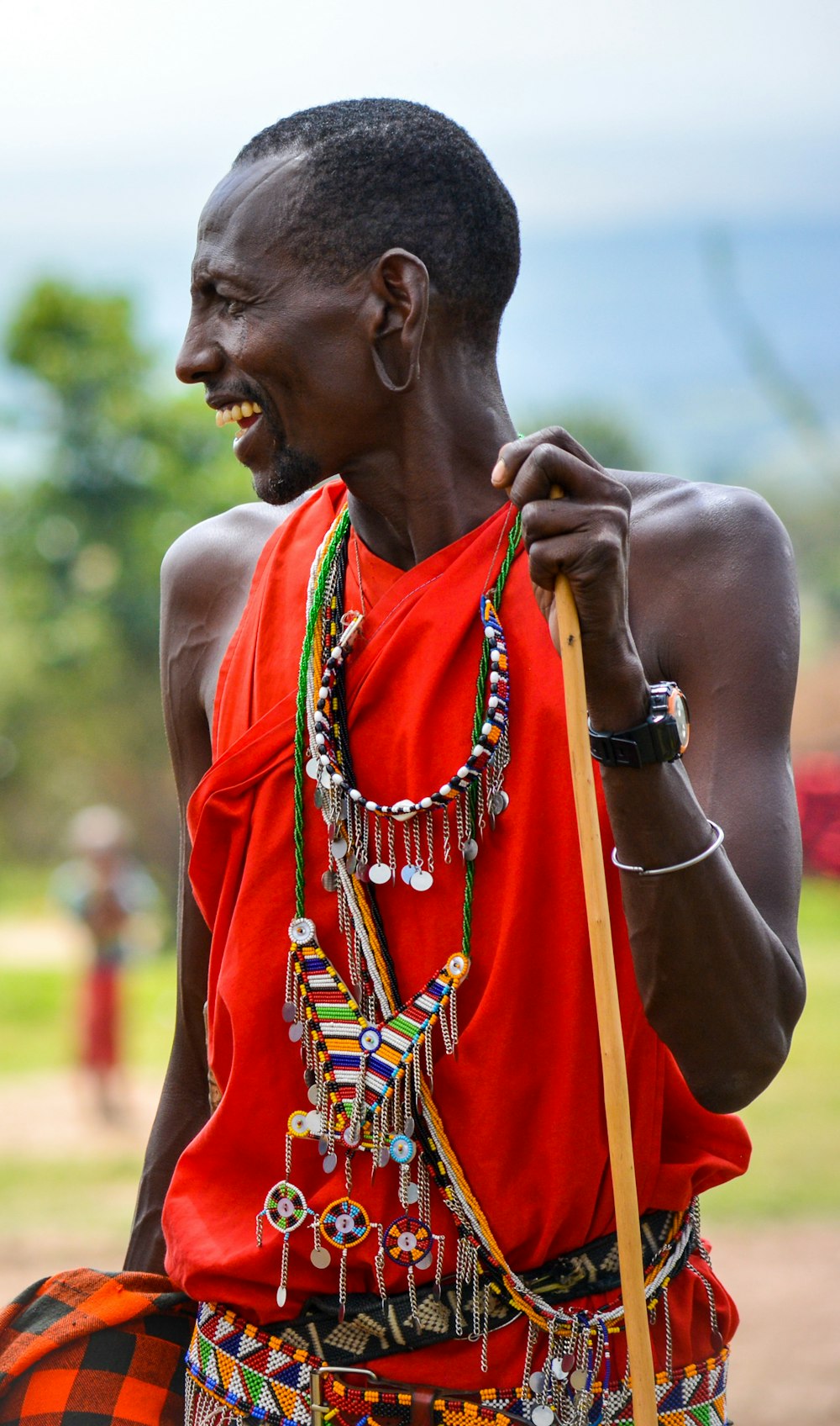 smiling man standing and facing his right side