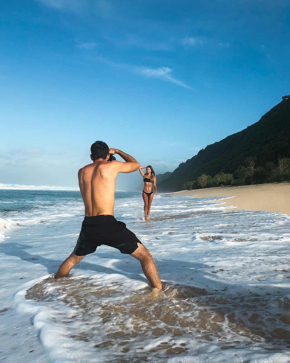 a man standing on top of a sandy beach next to the ocean