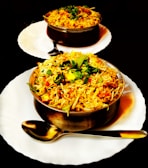 two plates of food on a black table