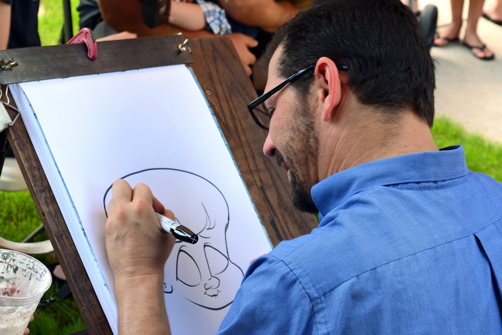 man in blue collared shirt sketching