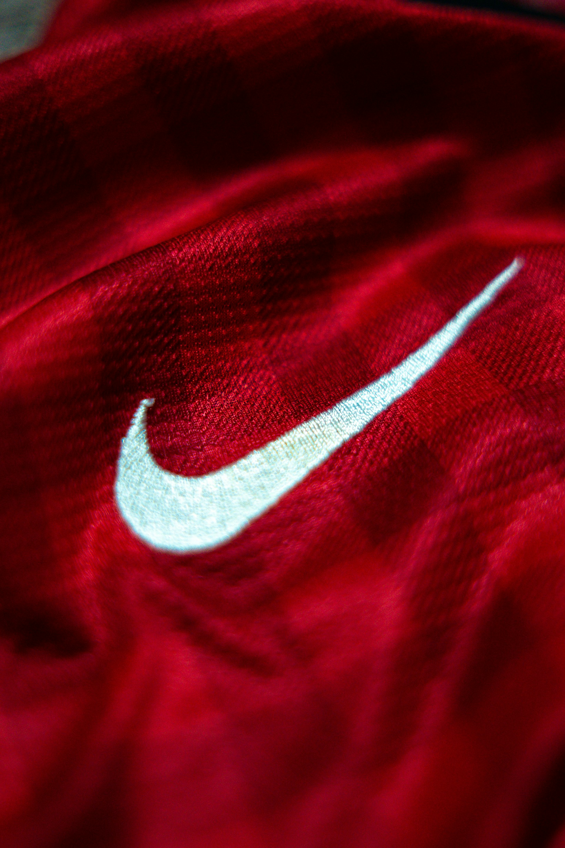 a red shirt with a white nike logo on it