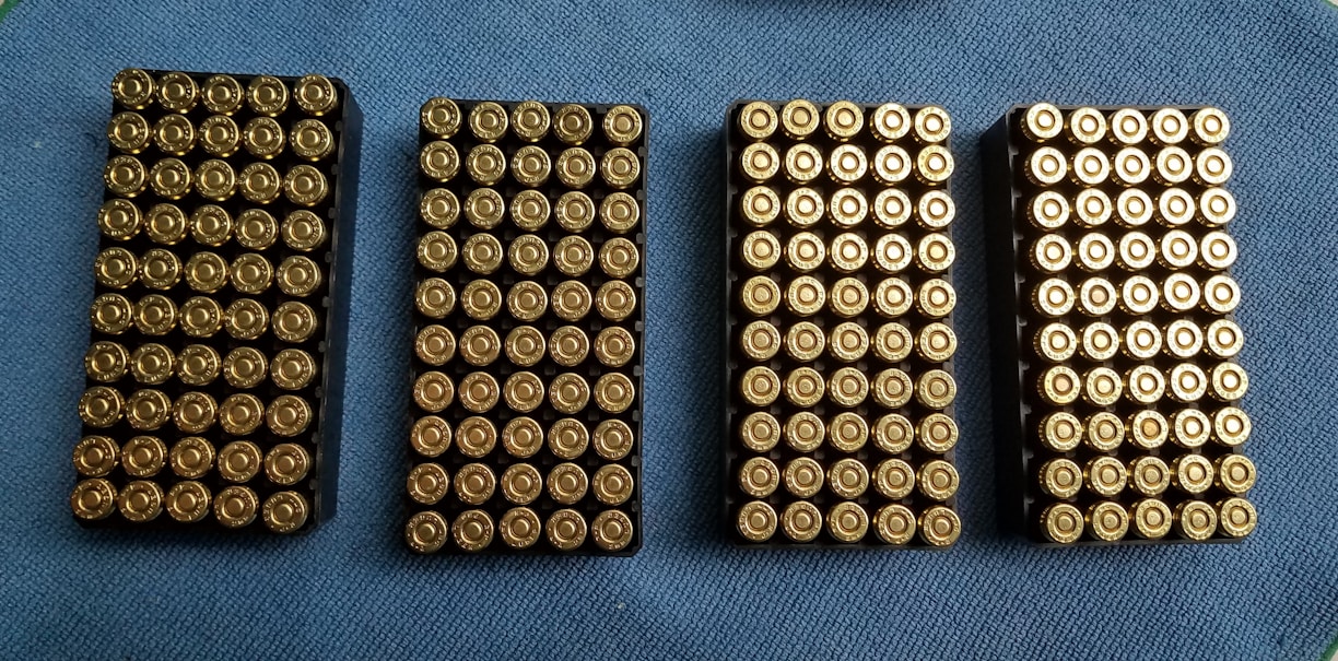 Close-up of various ammunition rounds neatly arranged on a wooden surface