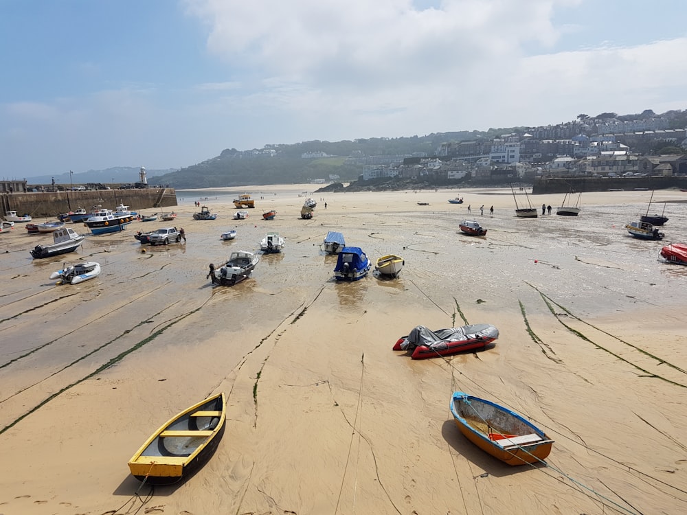 a group of boats sitting on top of a sandy beach