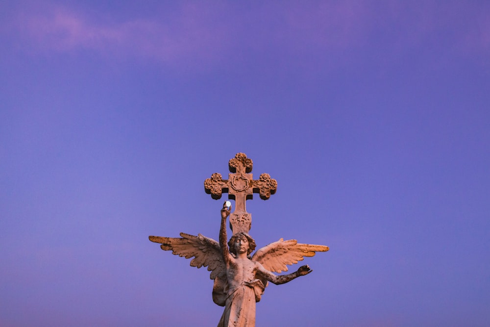 angel and cross statue during day